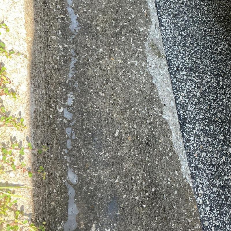 Water heater flushing residue on ground near curb Water heater flushing residue on ground near curb