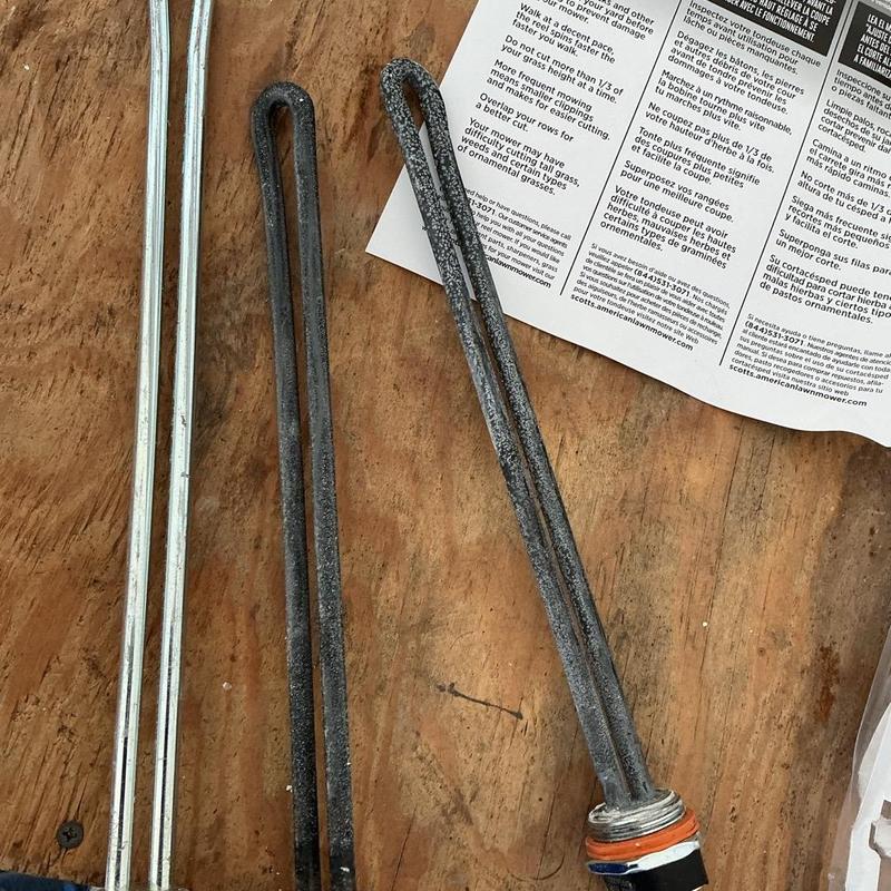 Water heater heating elements on wood surface Water heater heating elements on wood surface