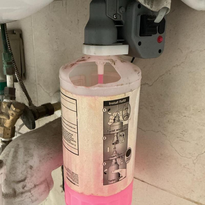 Soap dispenser refill bottle installed under sink Soap dispenser refill bottle installed under sink