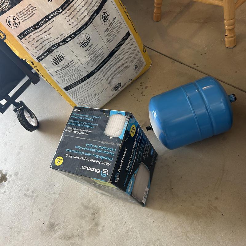 Expansion tank and water softener replacement parts on floor Expansion tank and water softener replacement parts on floor
