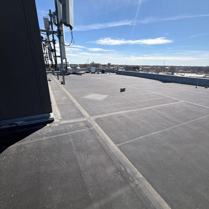 Flat commercial roof with cellular antennas and vents Flat commercial roof with cellular antennas and vents