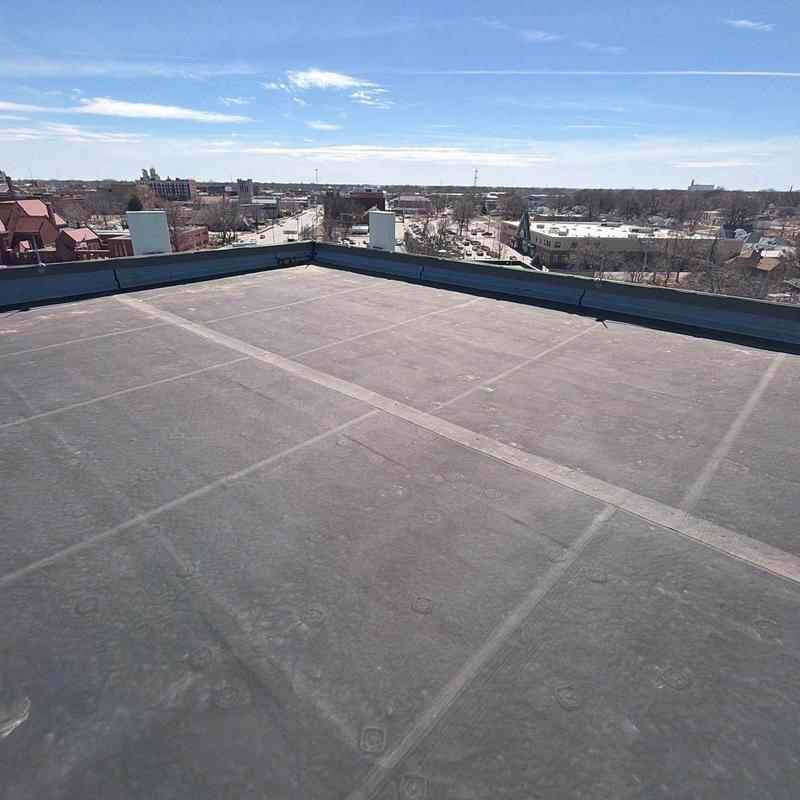 Flat roof membrane inspection with city view Flat roof membrane inspection with city view