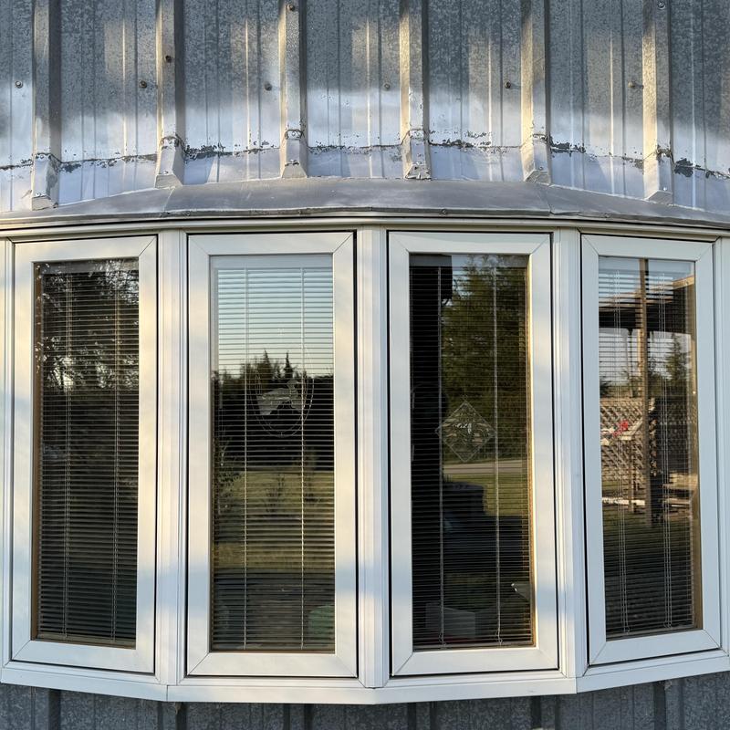 Vinyl bay window with blinds on metal siding Vinyl bay window with blinds on metal siding