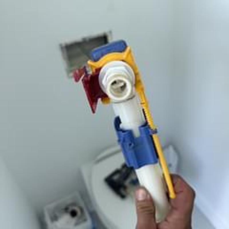 Toilet fill valve assembly held by technician hand Toilet fill valve assembly held by technician hand