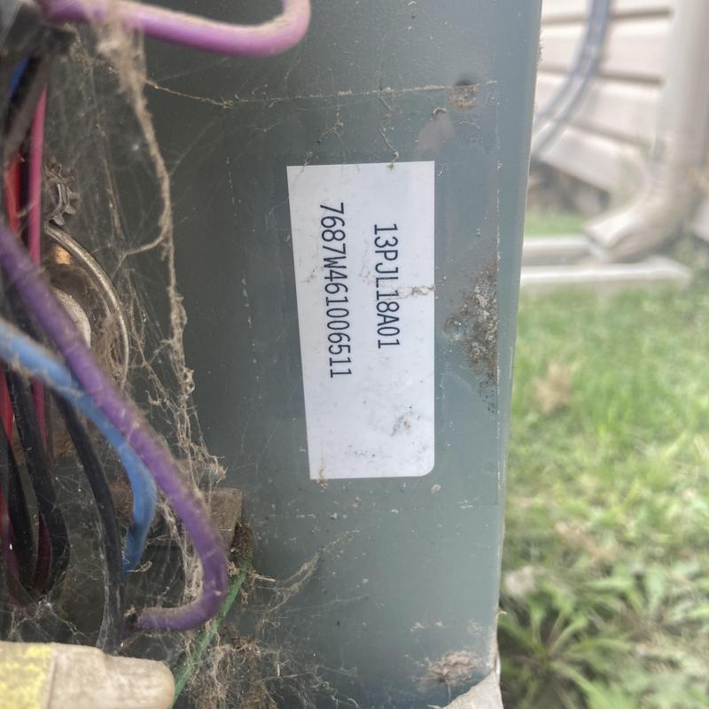 HVAC condenser unit wiring and label with cobwebs