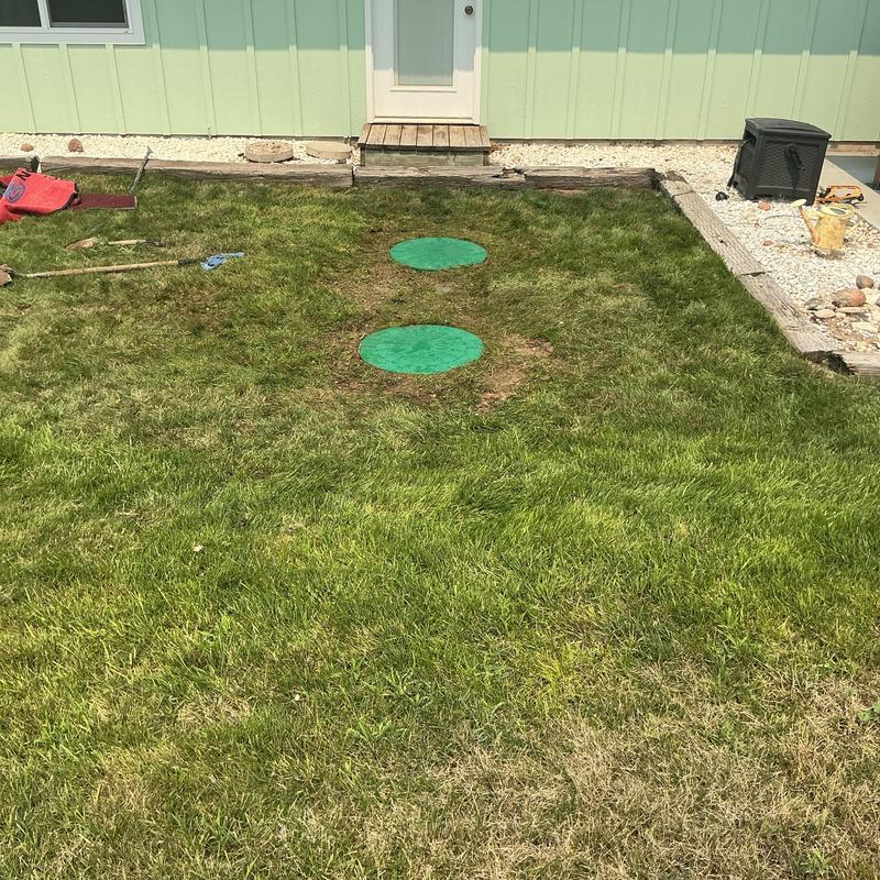 Septic tank risers with green lids in lawn Septic tank risers with green lids in lawn