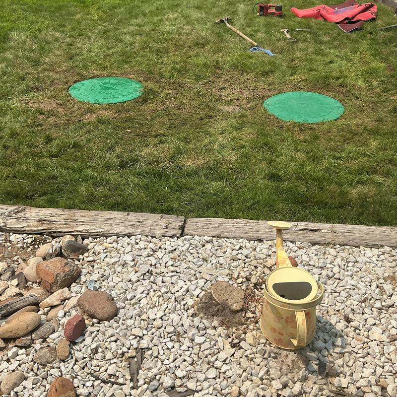 Septic tank risers and lids in grassy yard Septic tank risers and lids in grassy yard