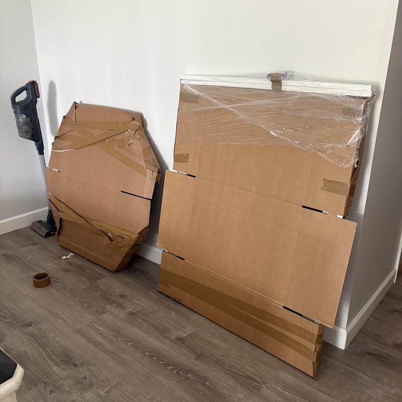 Furniture wrapped and packed for moving in cardboard sheets