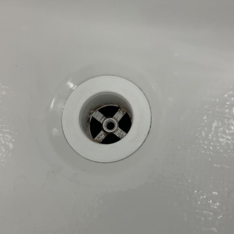 Bathtub drain with crossbar in white tub basin Bathtub drain with crossbar in white tub basin