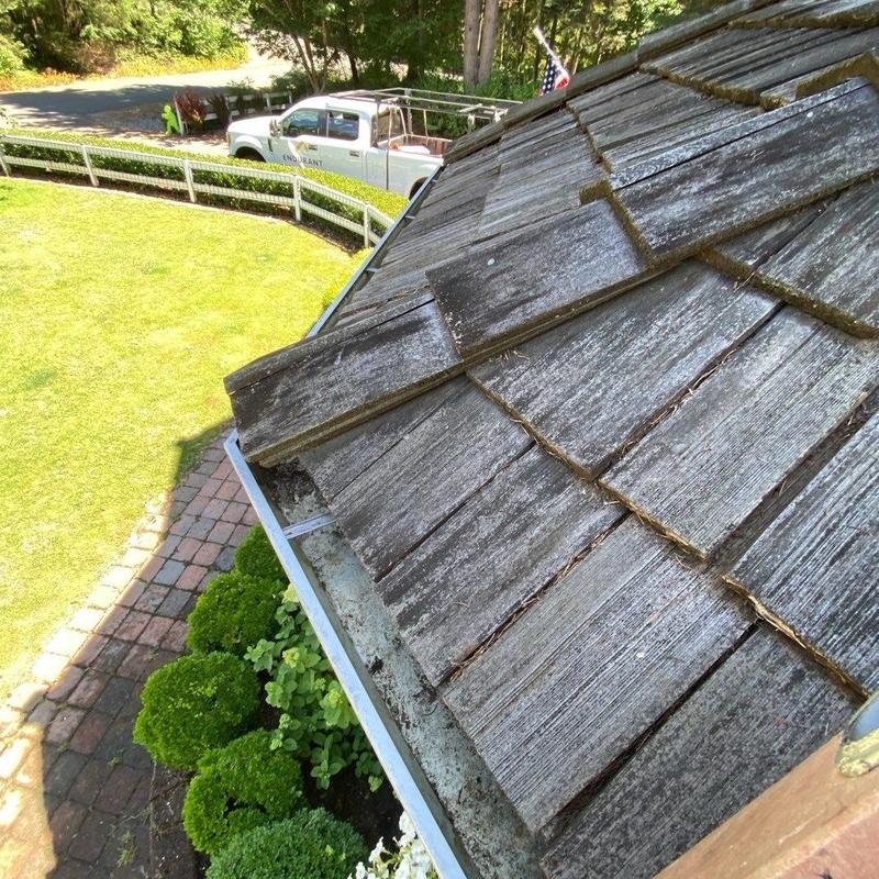 Wood shingle roof with weathered damage near gutter