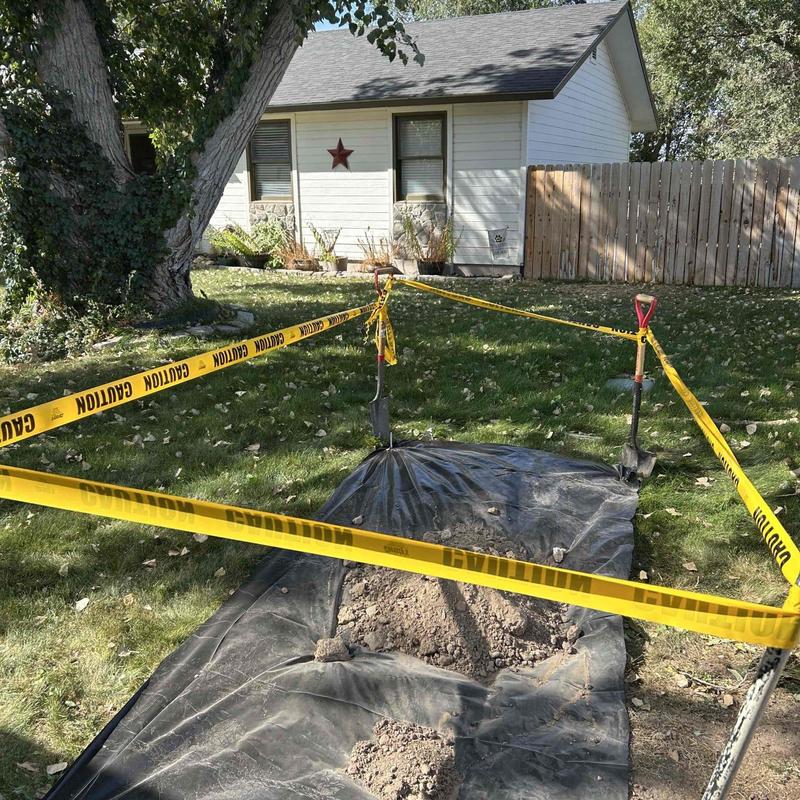 Water meter excavation with caution tape and shovels