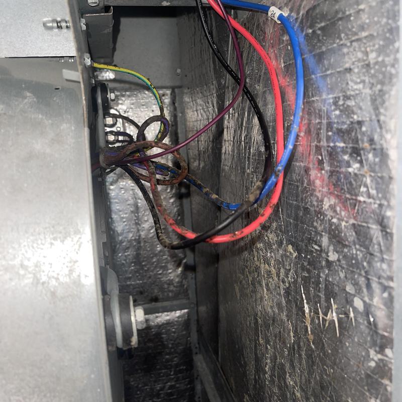 Heat pump wiring inside metal panel with colored cables