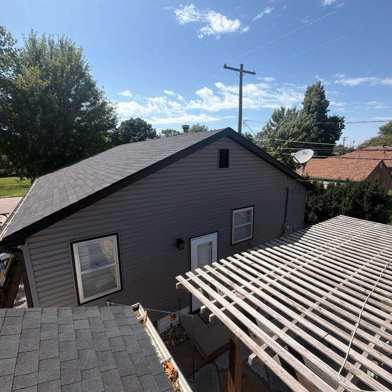 Asphalt shingle roof and wooden pergola structure outside house Asphalt shingle roof and wooden pergola structure outside house