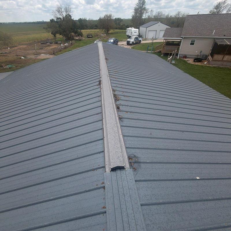 Metal roof ridge cap with screw fasteners and debris Metal roof ridge cap with screw fasteners and debris