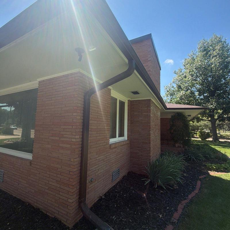 Downspout and gutter system on brick house exterior Downspout and gutter system on brick house exterior