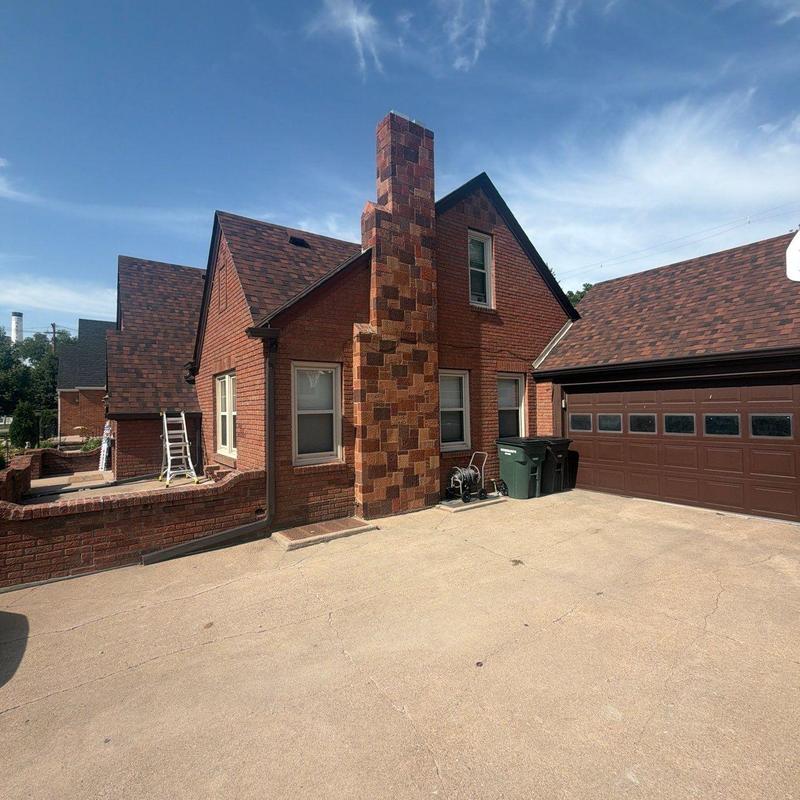 Asphalt shingle roof and brick chimney on residential house Asphalt shingle roof and brick chimney on residential house