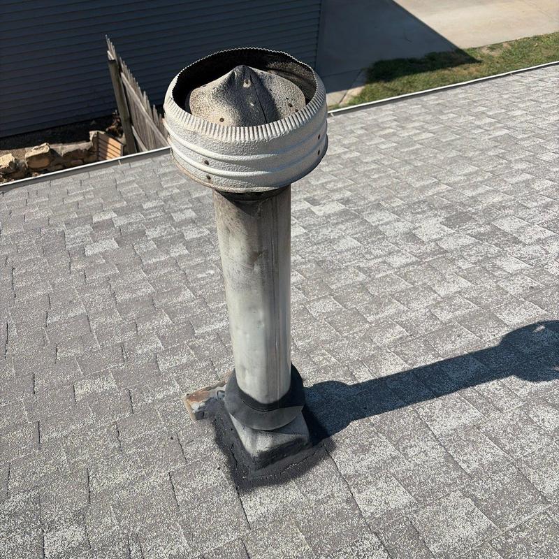 Roof vent pipe with metal cap on asphalt shingles Roof vent pipe with metal cap on asphalt shingles