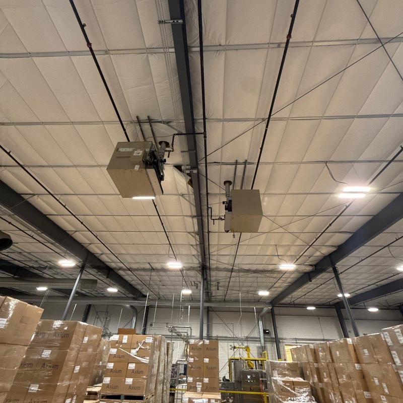 Ceiling-mounted industrial heaters in warehouse ceiling