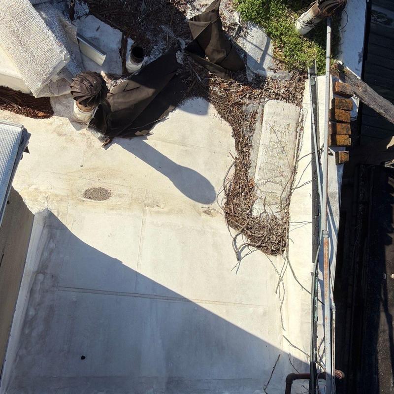 Flat roof membrane with debris and ventilation pipes