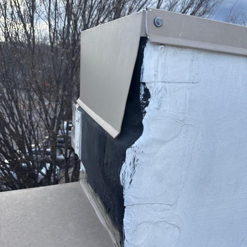 Roof flashing with hail damage on commercial roof edge