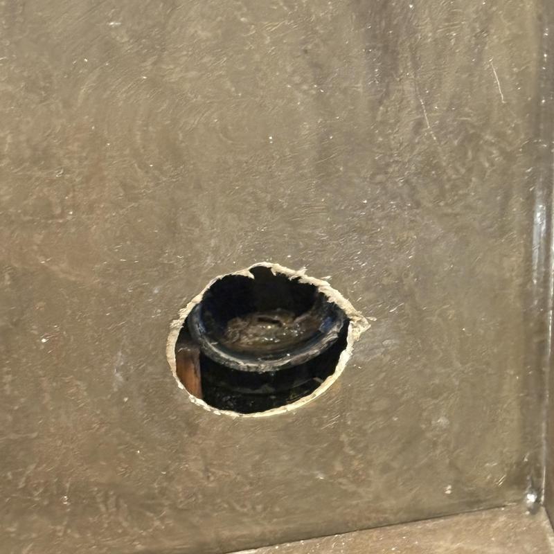 Mainline pipe hole cut in wall for inspection access Mainline pipe hole cut in wall for inspection access