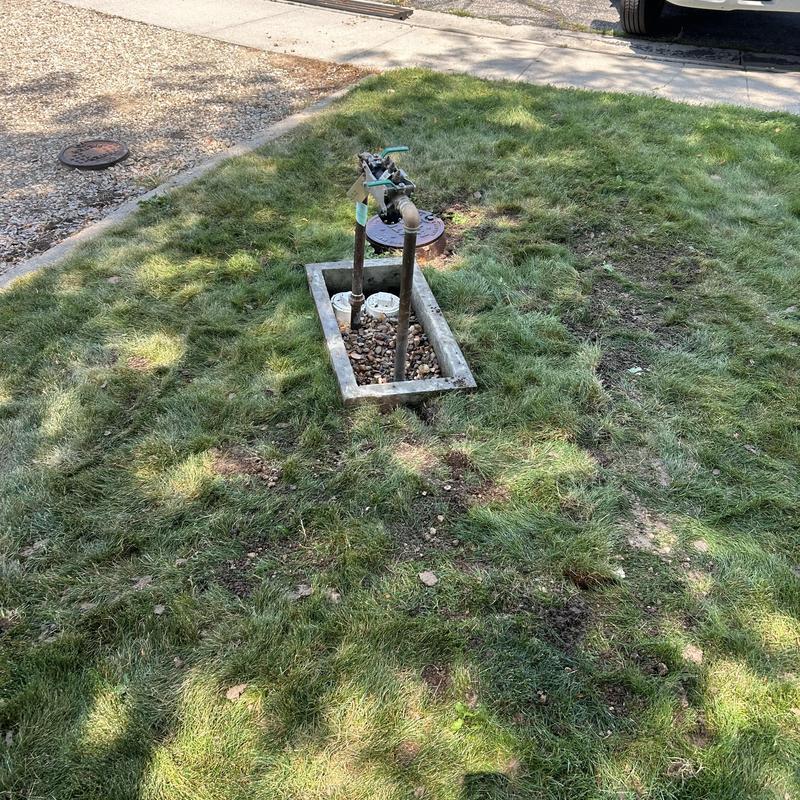 Backflow device piping in yard with grass and valve Backflow device piping in yard with grass and valve