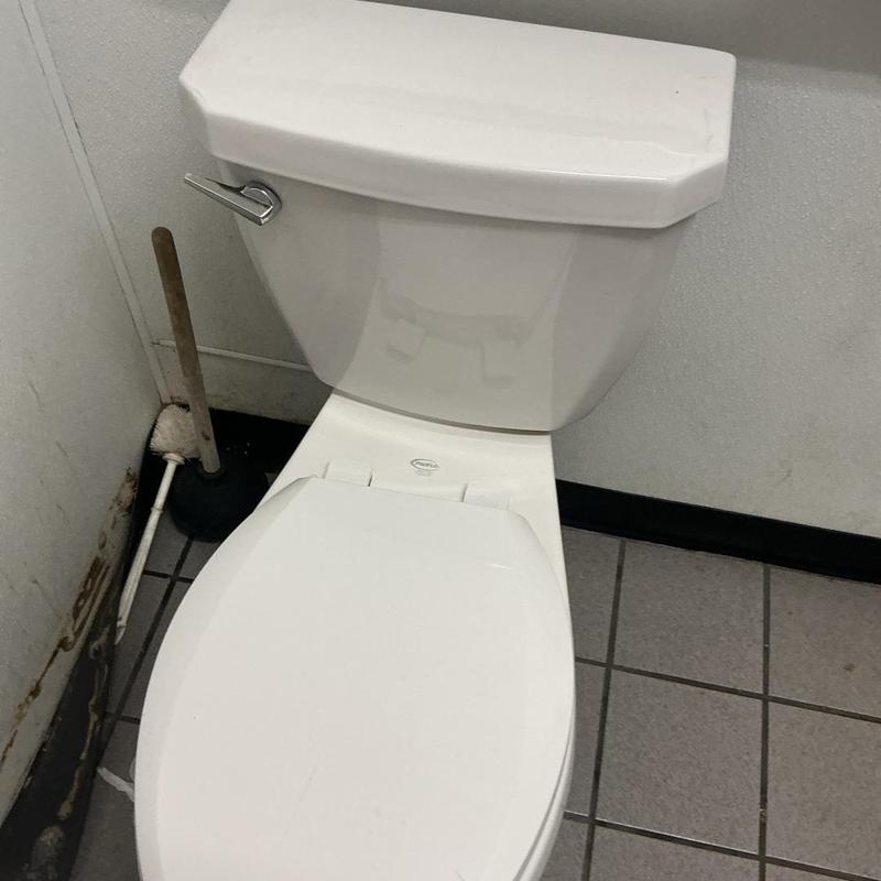 Toilet handle on men's restroom toilet with tank and seat Toilet handle on men's restroom toilet with tank and seat