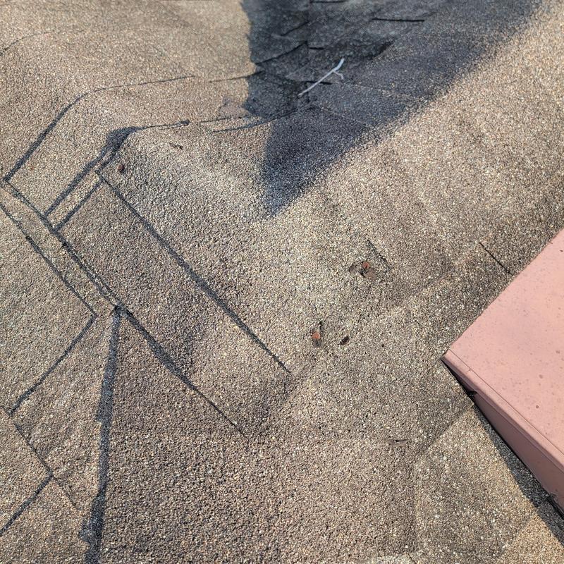 Asphalt roof shingles with exposed nail damages Asphalt roof shingles with exposed nail damages