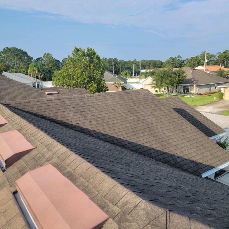 Asphalt shingle roof with vent caps and nearby homes Asphalt shingle roof with vent caps and nearby homes