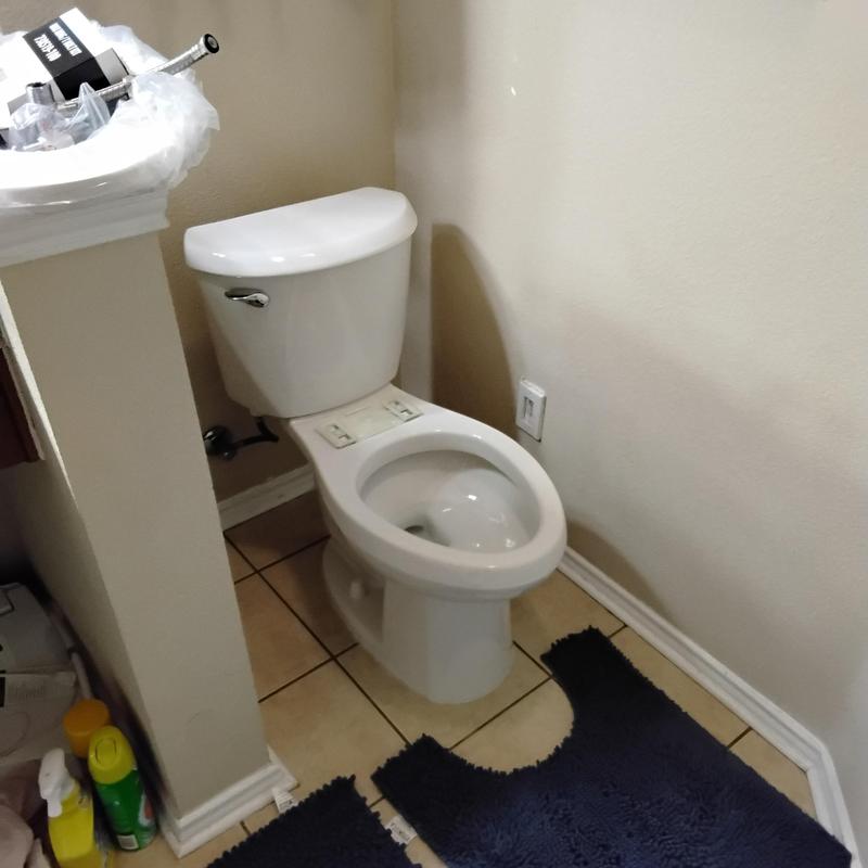 Toilet installation with tank and bowl in bathroom corner