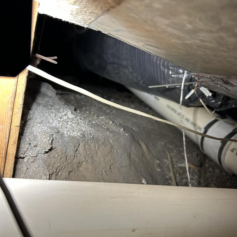 PVC drain pipe with wiring in crawl space access PVC drain pipe with wiring in crawl space access