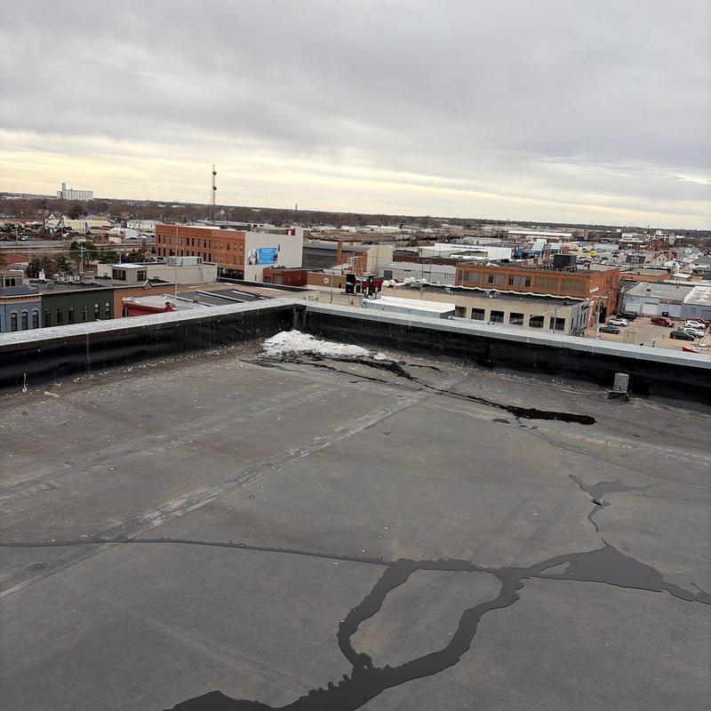 Flat roof membrane with visible cracks and pooling water Flat roof membrane with visible cracks and pooling water