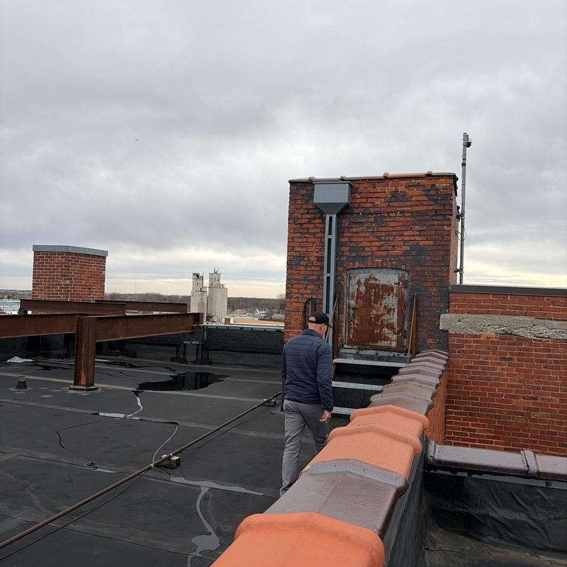 Flat roof membrane inspection with chimney nearby Flat roof membrane inspection with chimney nearby