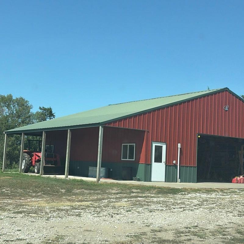 Metal roof on red farm building with open garage door Metal roof on red farm building with open garage door