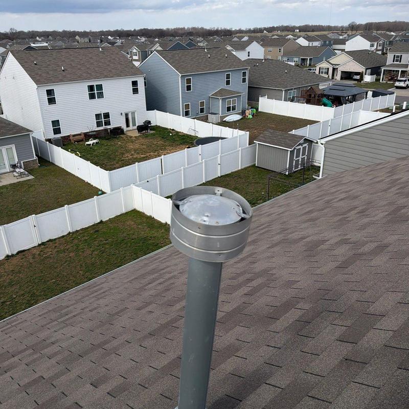 Roof vent with hail-damaged metal cap on shingle roof