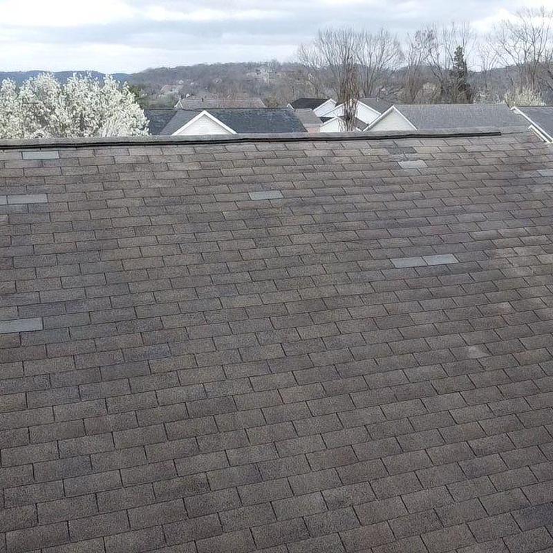 Asphalt shingle roof with visible hail damage spots
