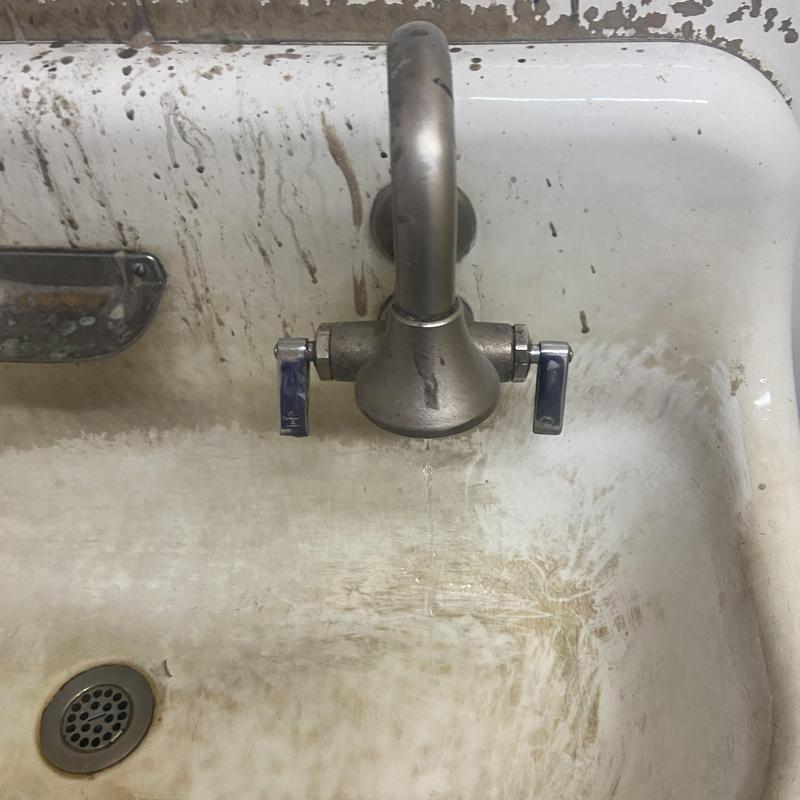 Break room faucet leaking over stained sink basin Break room faucet leaking over stained sink basin