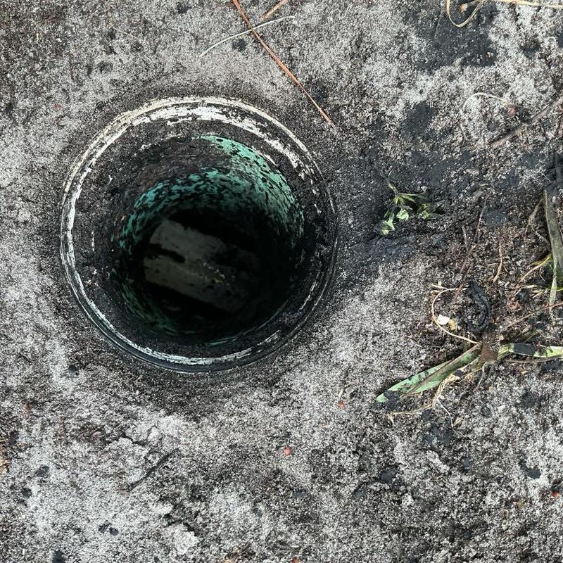 Clean out pipe opening in sandy soil with debris Clean out pipe opening in sandy soil with debris