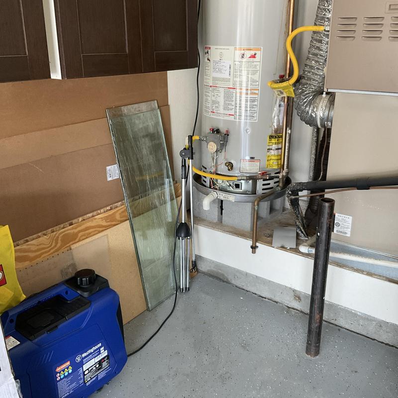 Water heater with connected gas and drain pipes in garage Water heater with connected gas and drain pipes in garage