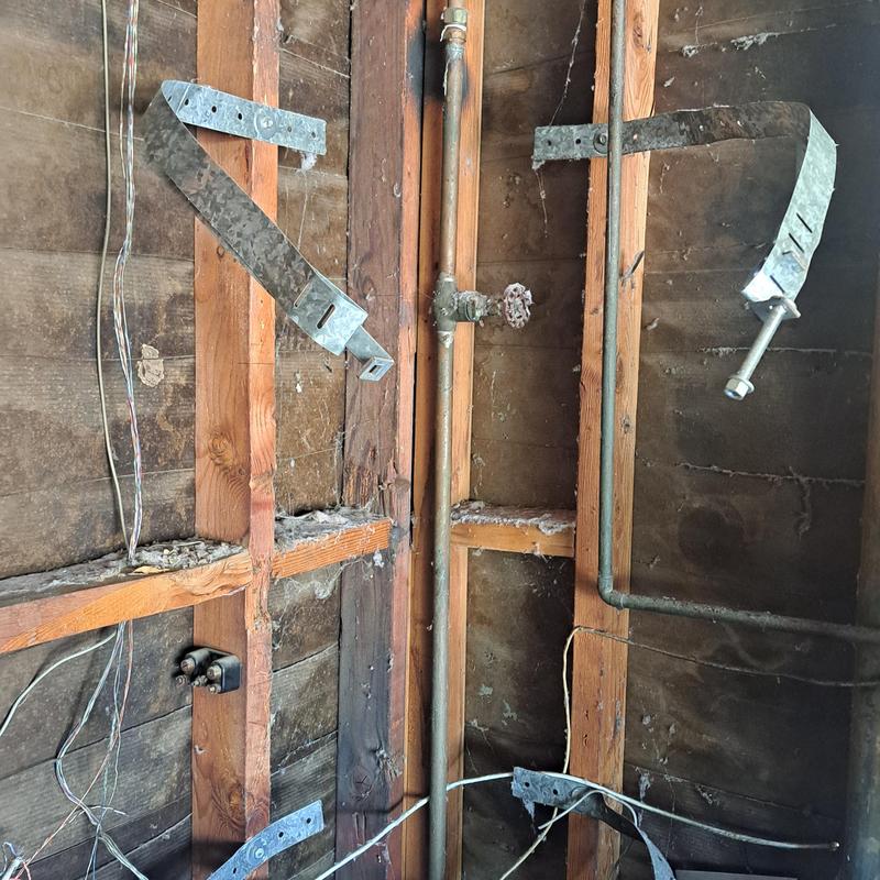 Gas supply pipe with wall framing and metal straps