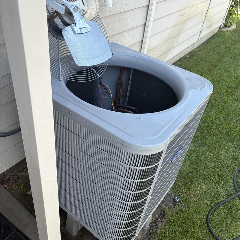 Outdoor HVAC condensing unit with fan removed for service