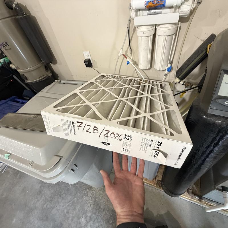 HVAC air filter replacing with dated filter visible