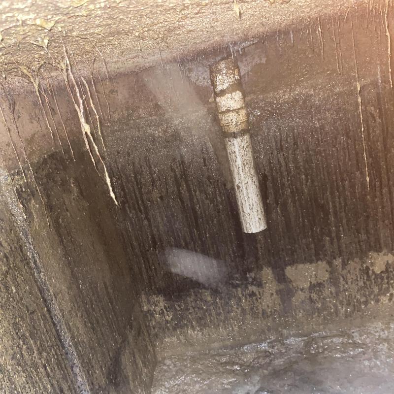 Septic tank interior with solids buildup and pipe outlet Septic tank interior with solids buildup and pipe outlet