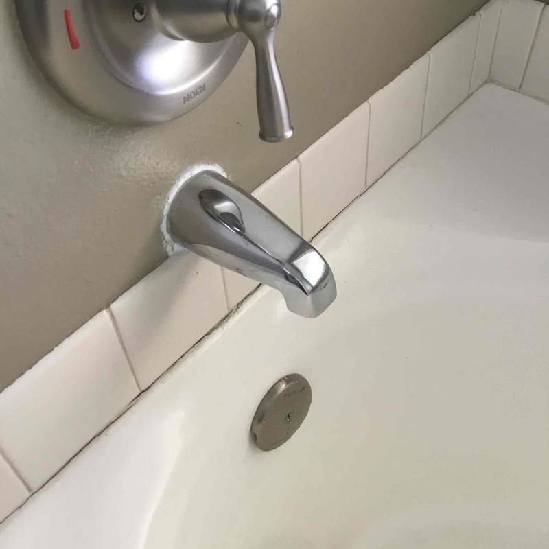 Tub spout with chrome finish on bathtub wall Tub spout with chrome finish on bathtub wall