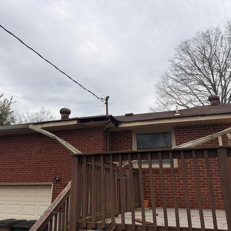 Roof gutters bent and detached from brick house exterior