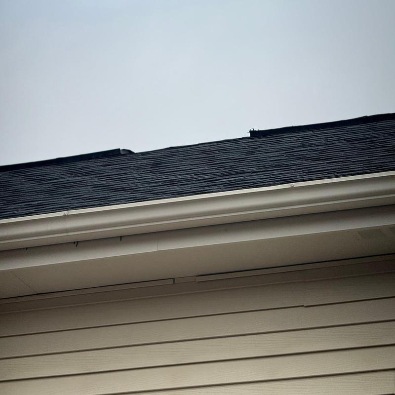 Asphalt shingle roof with hail damage near gutter line