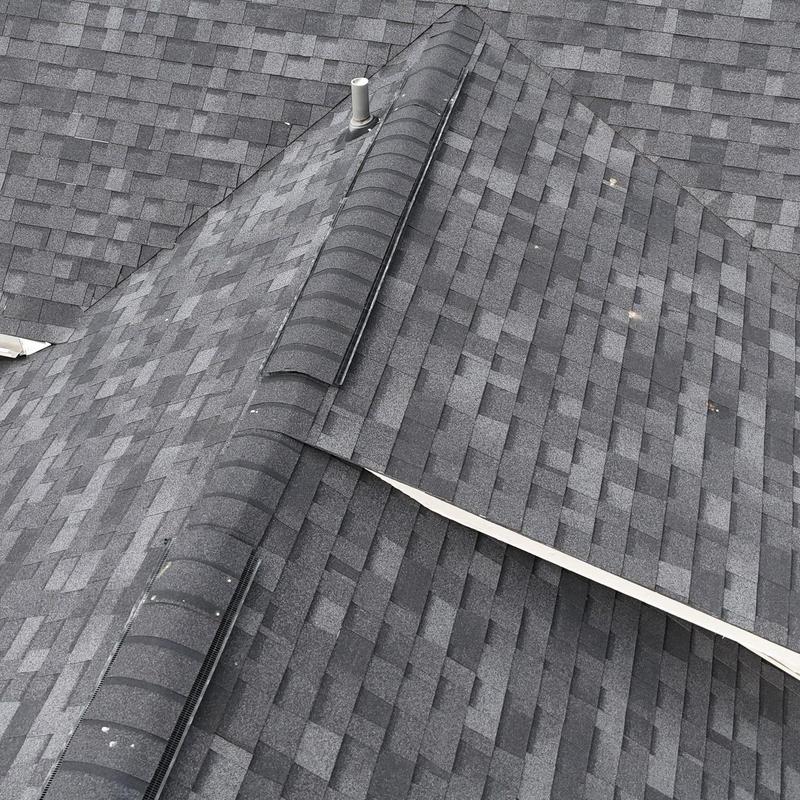 Asphalt shingle roof with hail damage spots and ridge vents
