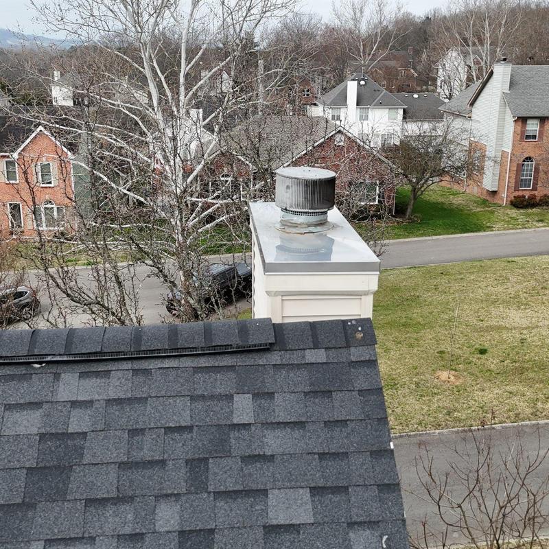 Roof shingles with hail damage near chimney vent