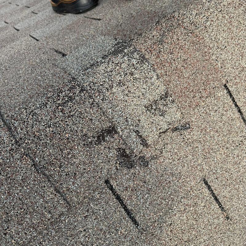 Hail-damaged asphalt shingles on roof surface