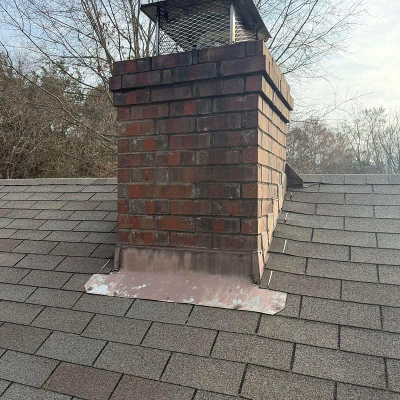 Roof chimney flashing with weathered sealant on shingles